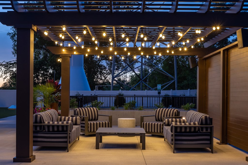 a patio with chairs and tables under a pergola