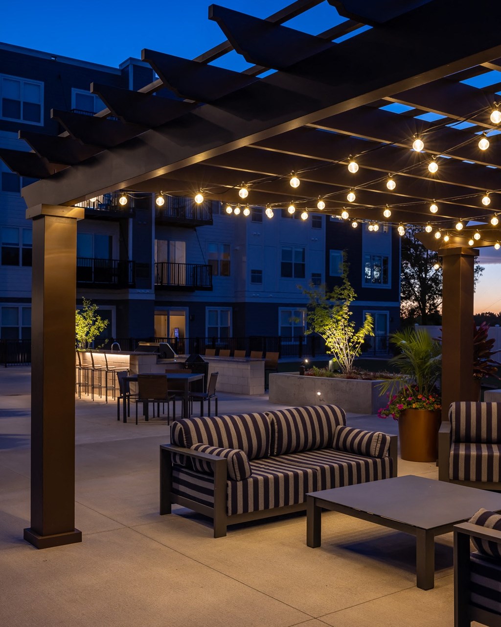 a patio with couches and tables at night