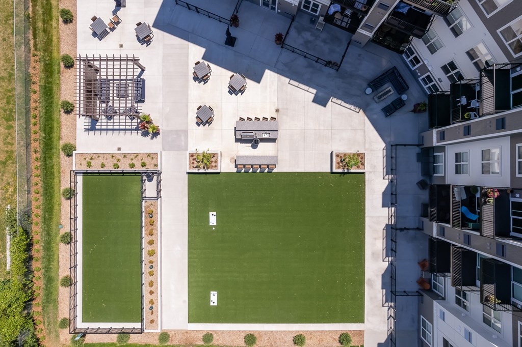an aerial view of an apartment complex with a green field and a lawn