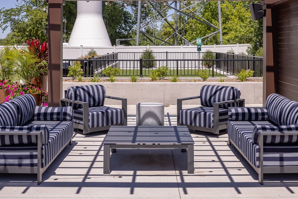 a patio with striped furniture and a coffee table