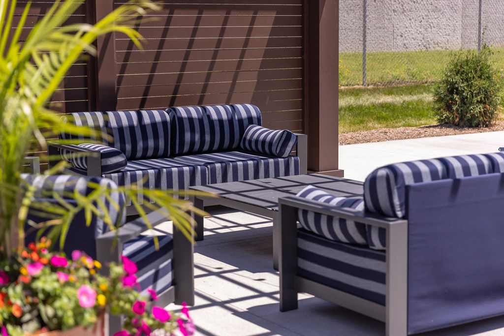 a patio with blue and white striped couches and tables
