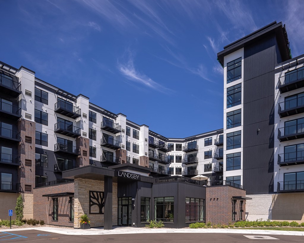 an exterior view of an apartment complex with a blue sky