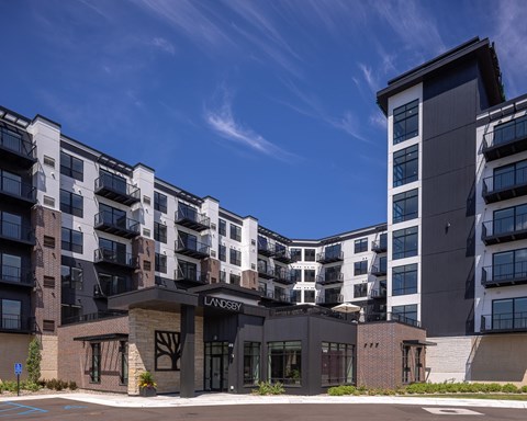 an exterior view of an apartment complex with a blue sky