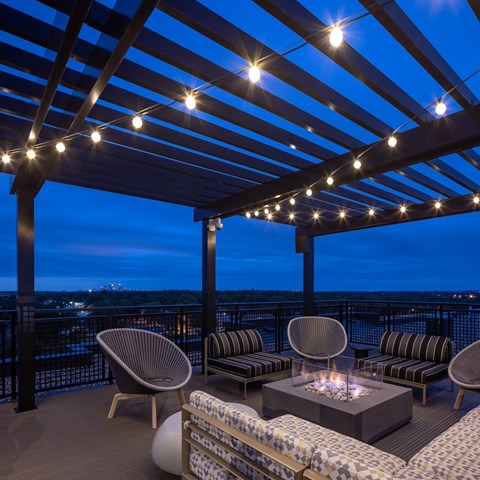 a roof top patio with chairs and a table with candles