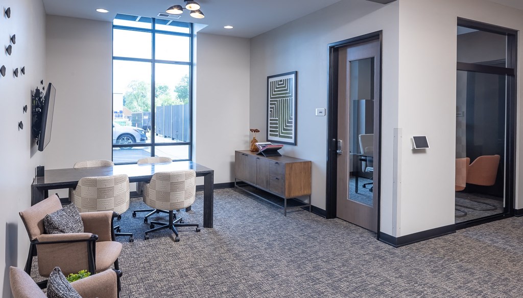 a conference room with chairs and a table in front of a glass door