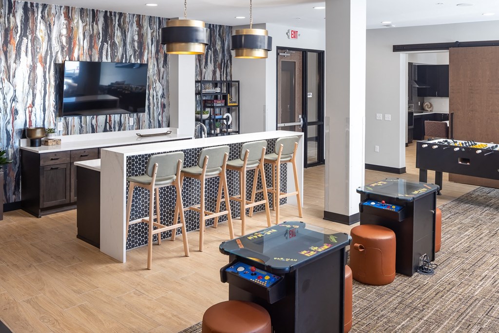 a game room with tables and chairs and a television