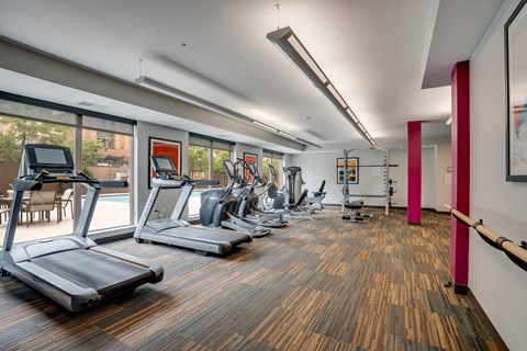 a gym with treadmills and other exercise equipment and windows