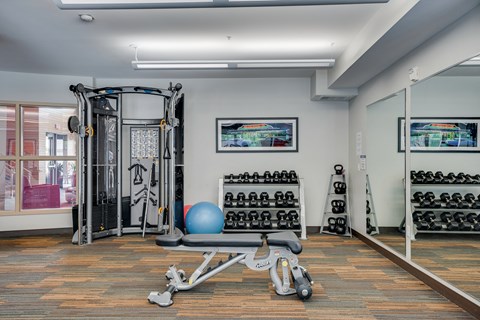 a gym with weights and exercise equipment and a window