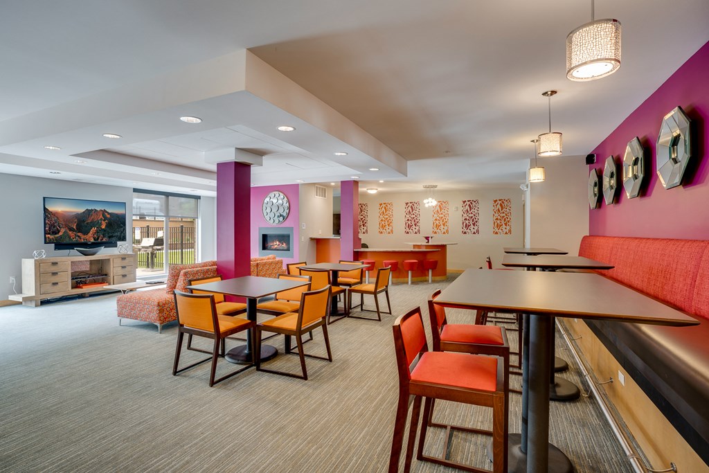 a dining area with tables and chairs and a pink divider