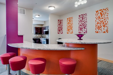 a kitchen with red stools and a counter with a counter top and a bar