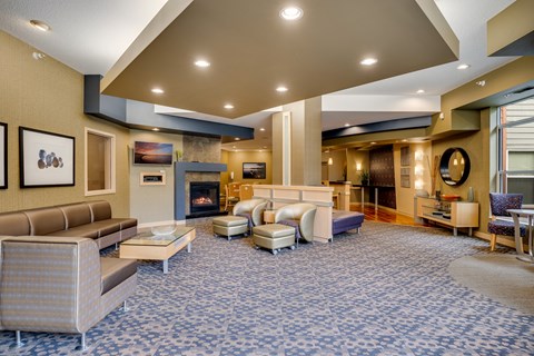 a large lobby with couches and chairs and a fireplace