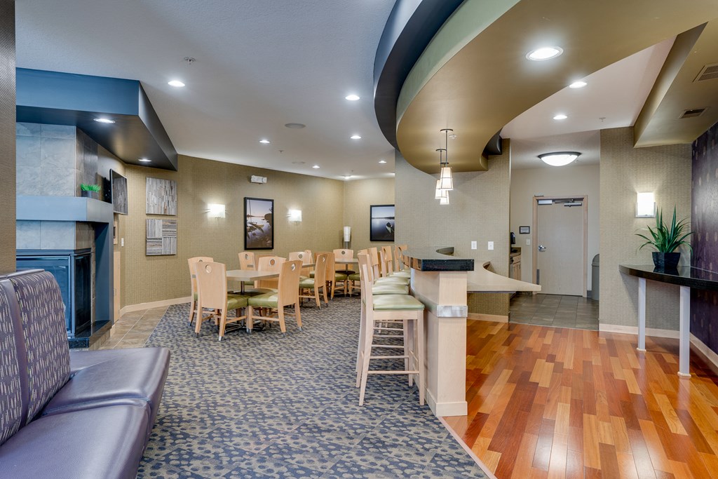 a community room with tables and chairs and a fireplace