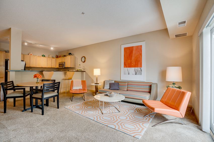 a living room with a couch and chairs and a dining table