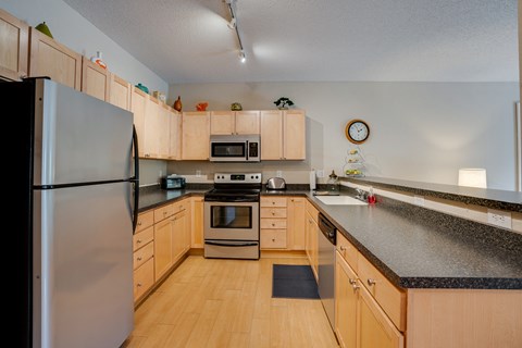 a kitchen with wooden cabinets and granite counter tops and stainless steel appliances