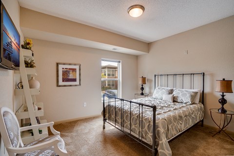 a bedroom with a bed and a chair and a window