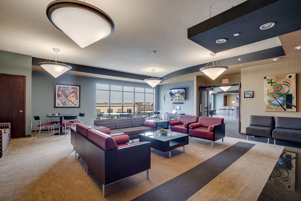 a lounge area with couches and chairs and a large window