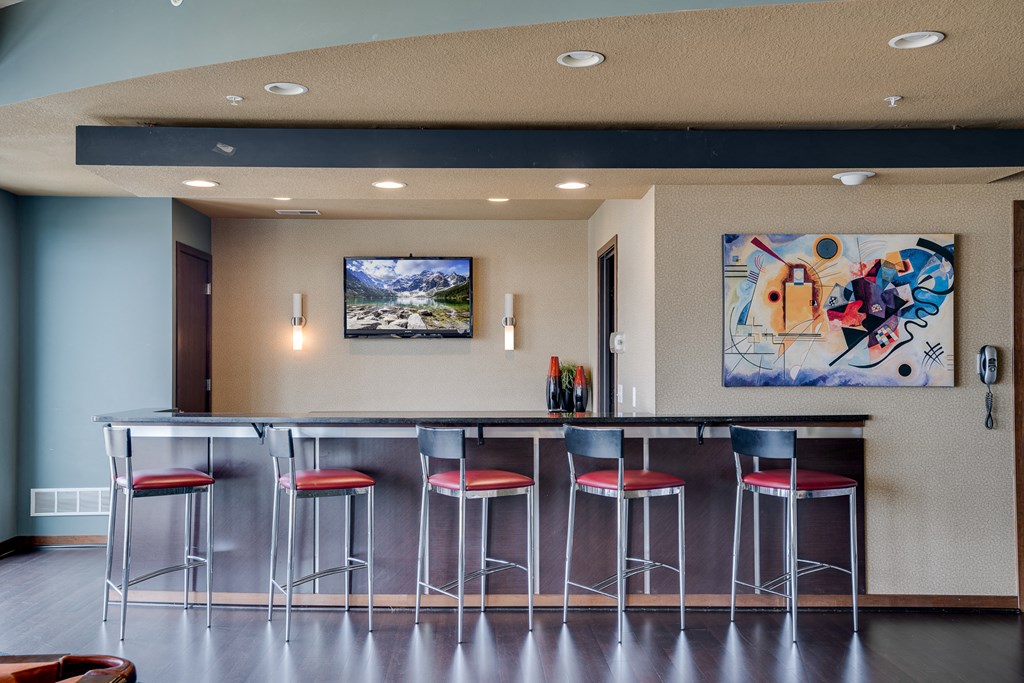 a bar with stools and a painting on the wall