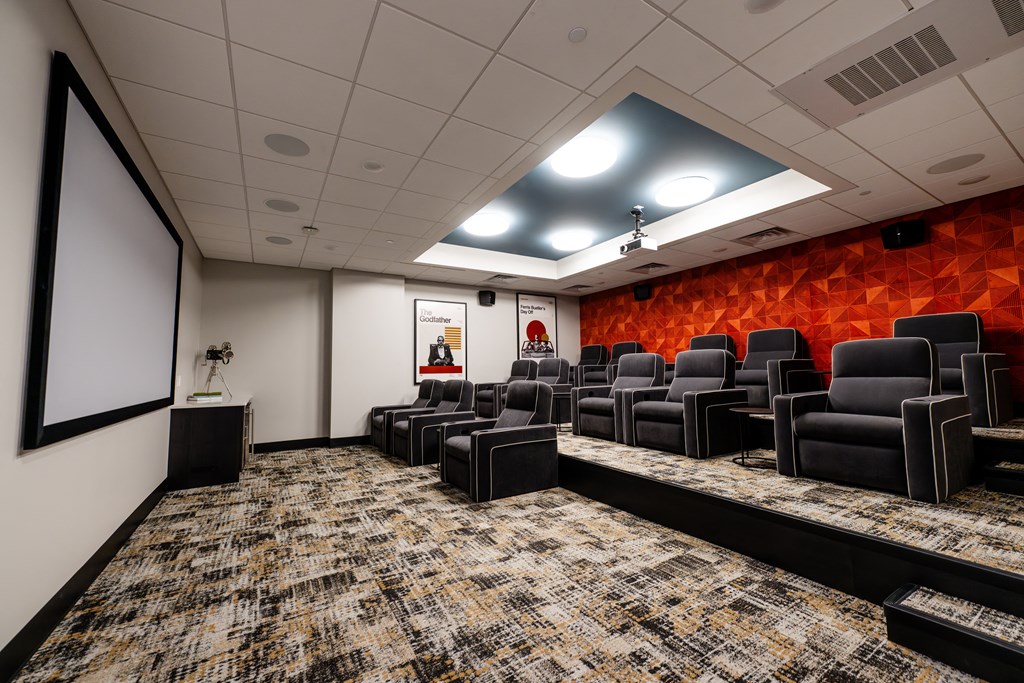 a room with a projector screen and chairs in it