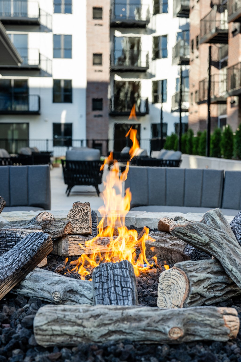 a fire pit on a patio with buildings in the background