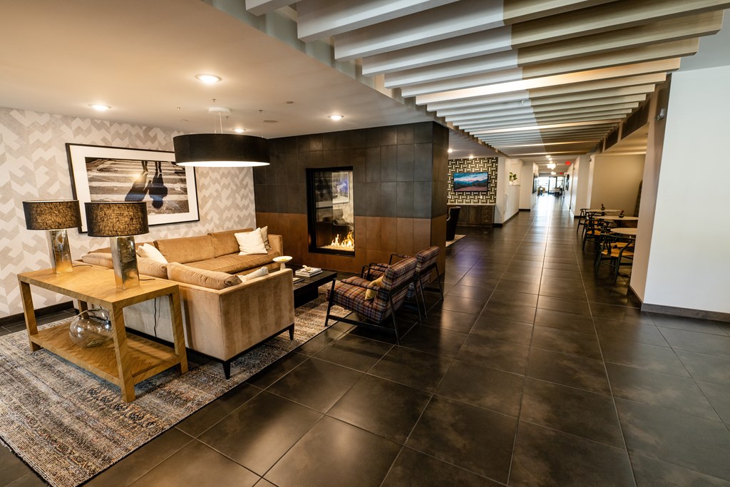 a long hallway with couches and tables and a fireplace