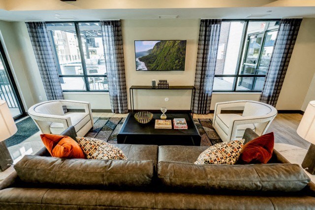 a living room with a couch and chairs and a television