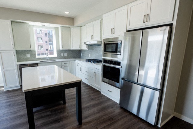 a kitchen with stainless steel appliances and white cabinets