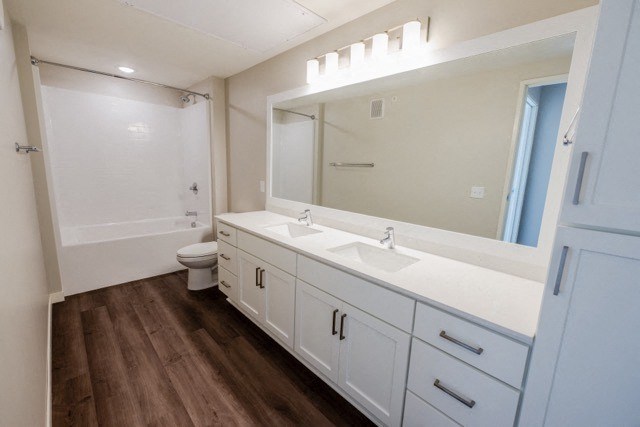 a bathroom with white cabinets and a sink and a mirror
