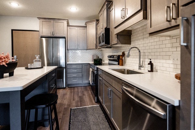 a kitchen with stainless steel appliances and white counter tops