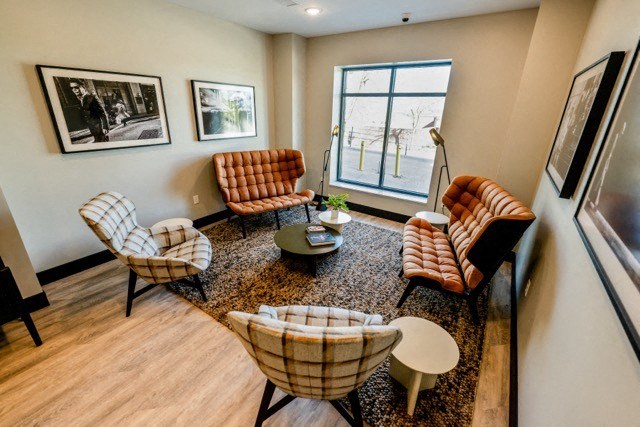 a living room with chairs and a table and a window