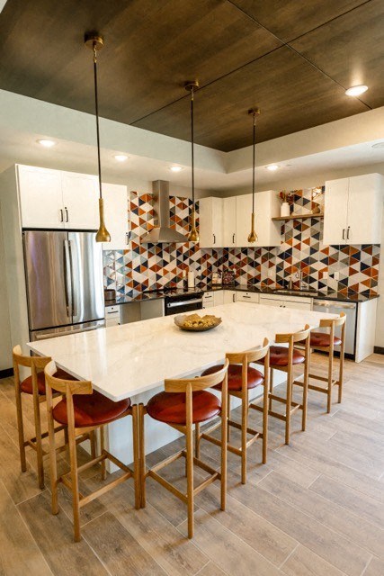 a kitchen with a marble counter top and chairs