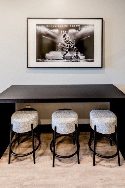 a bar with four stools and a picture on the wall