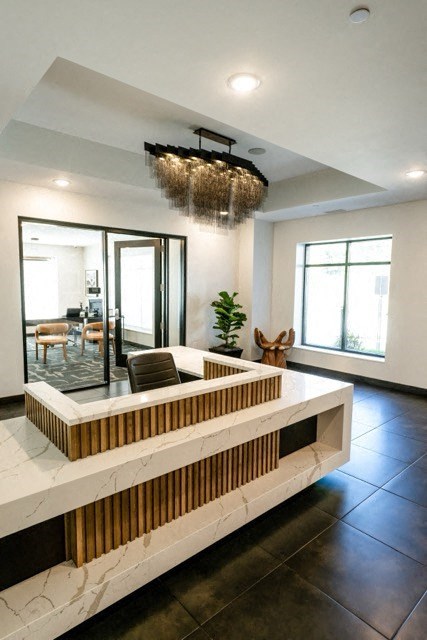 a lobby with a reception desk and a chandelier