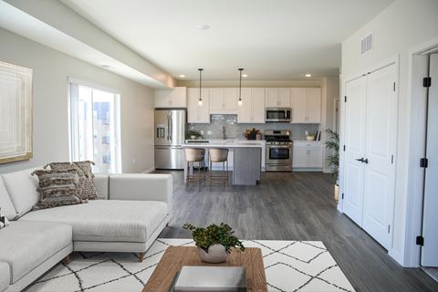 a living room and kitchen with white cabinets and a white couch