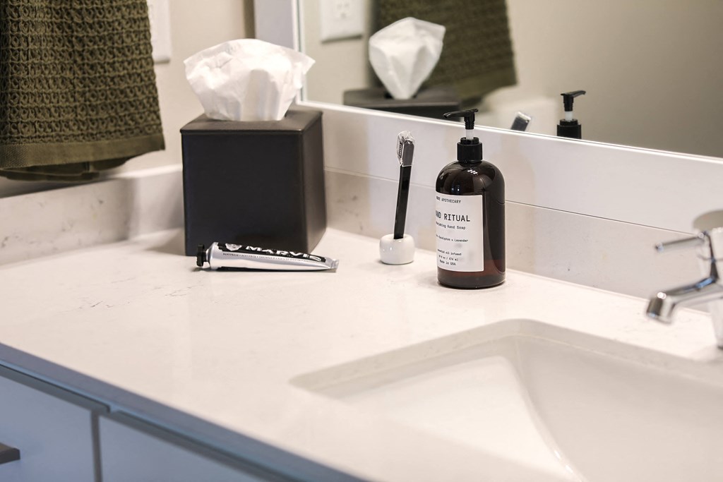 a bathroom sink with a bottle of lotion on it