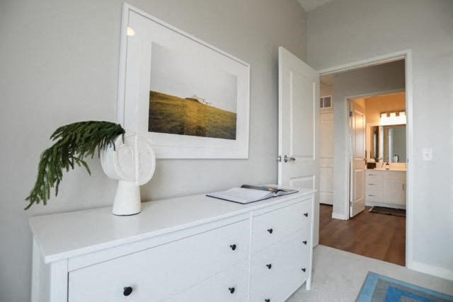 a white dresser with a white vase on top of it