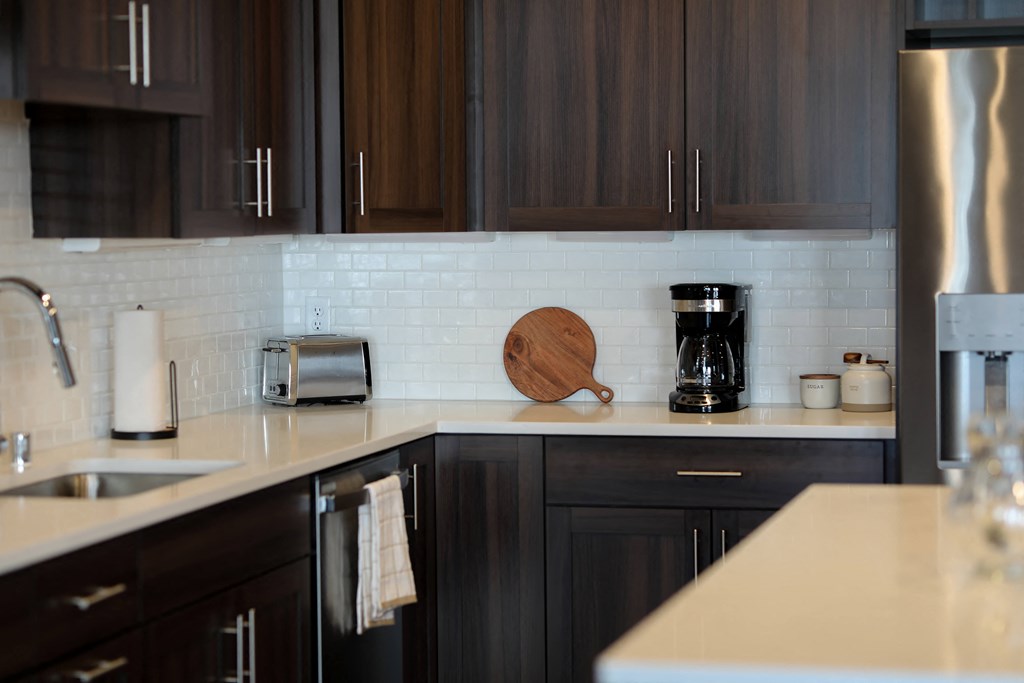 a kitchen with black cabinets and a counter top with a toaster and coffee maker