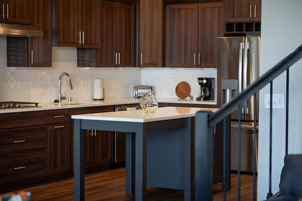 a kitchen with dark wood cabinets and a white counter top