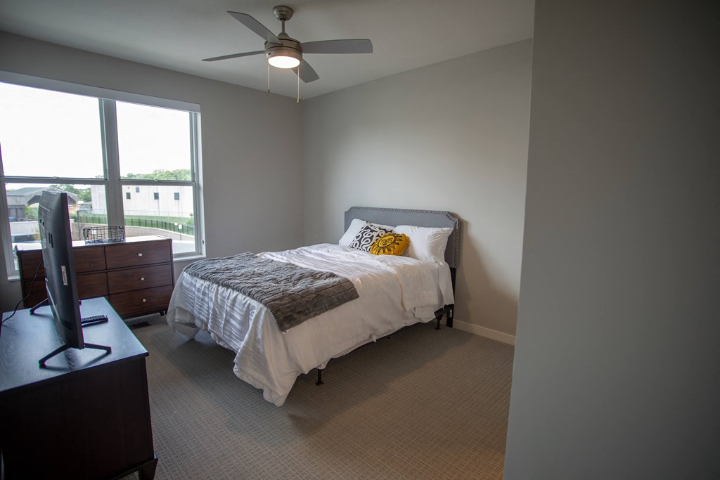 a bedroom with a bed and a ceiling fan