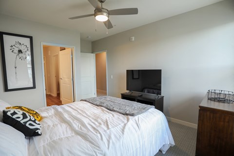 a bedroom with a large bed and a ceiling fan