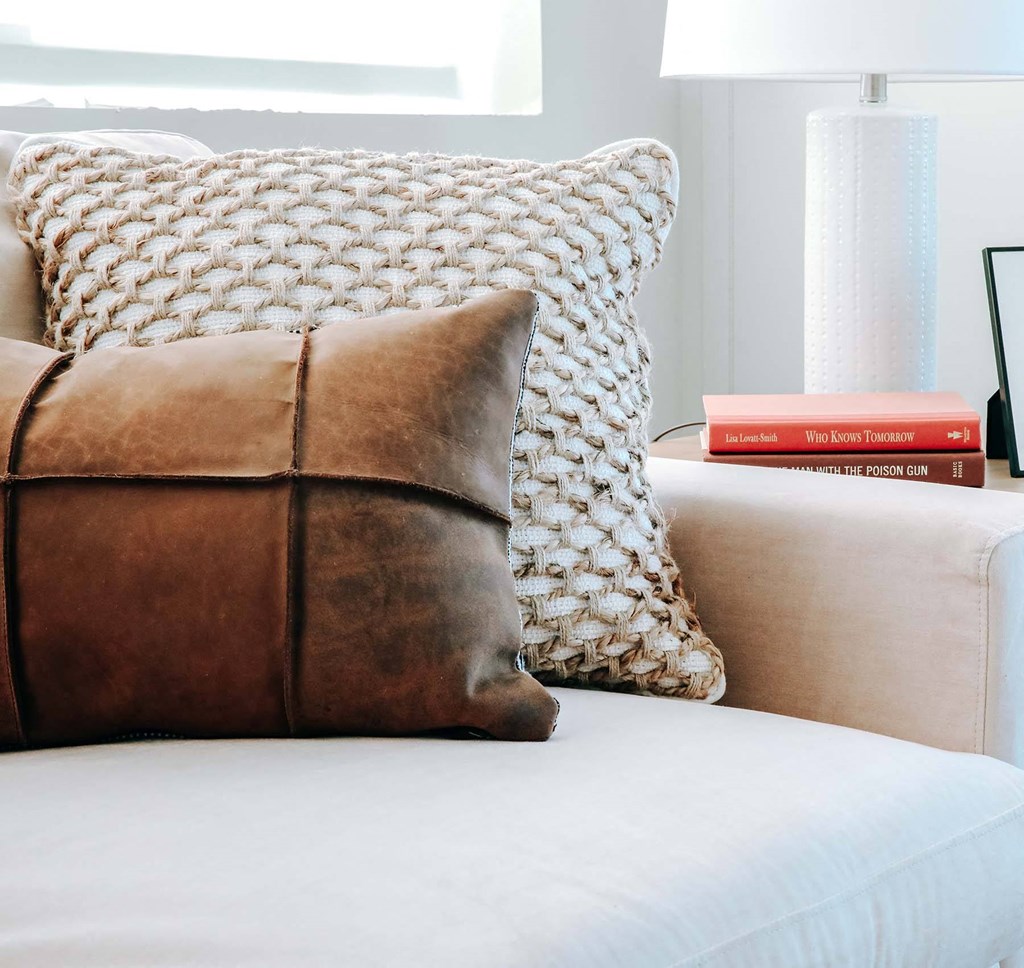 a white couch with a brown pillow on top of it