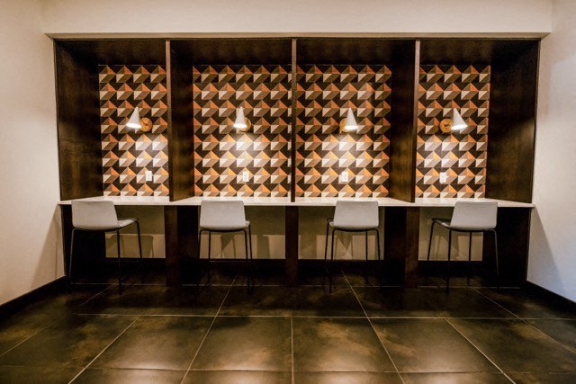 a dining area with a table and chairs and a wall with a patterned wallpaper