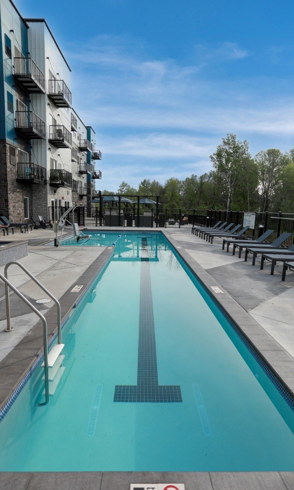 A long rectangular pool with a metal ladder on the side.