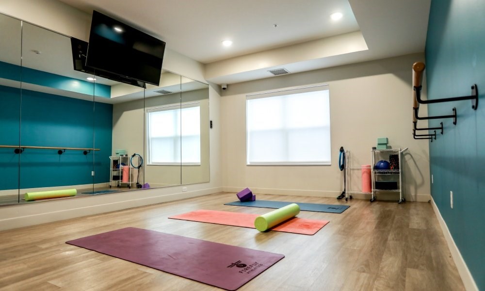 A yoga studio with a purple mat in the foreground.