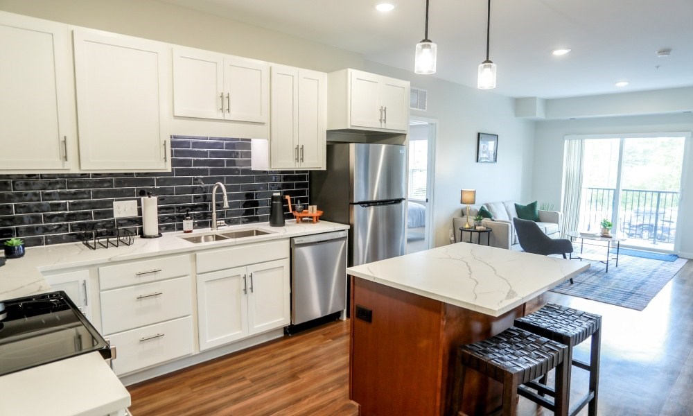 A kitchen with white cabinets and a wooden island.