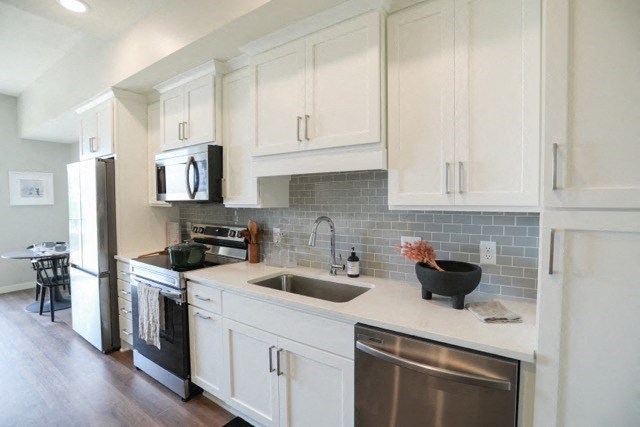 a kitchen with white cabinets and stainless steel appliances