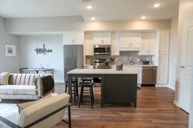 a kitchen with a center island next to a living room
