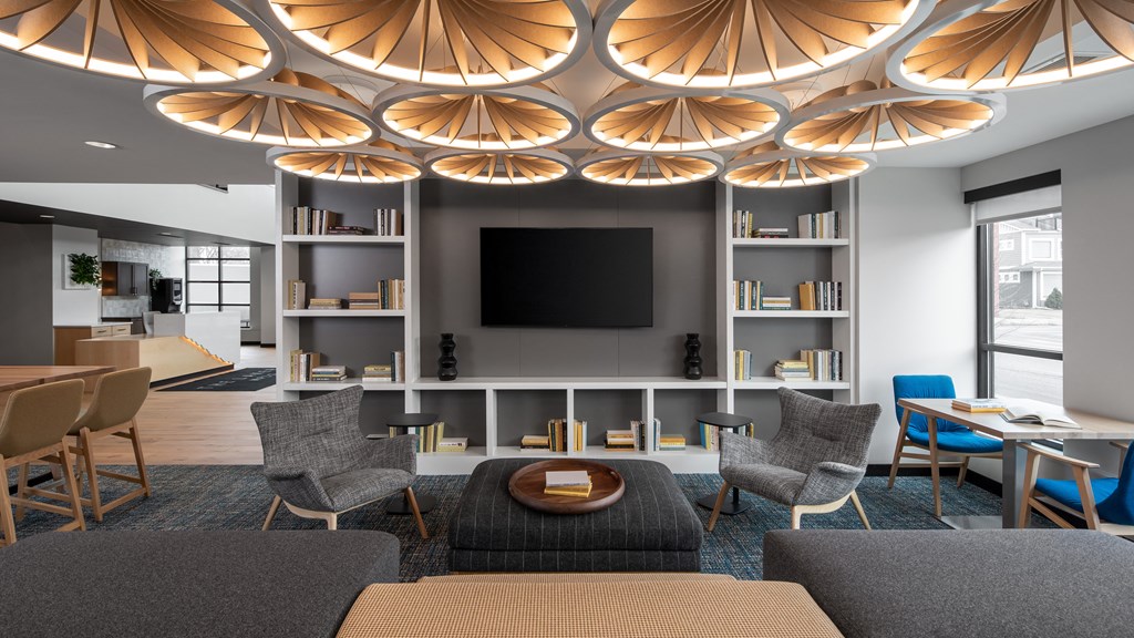 a living room with chairs and a table and a television