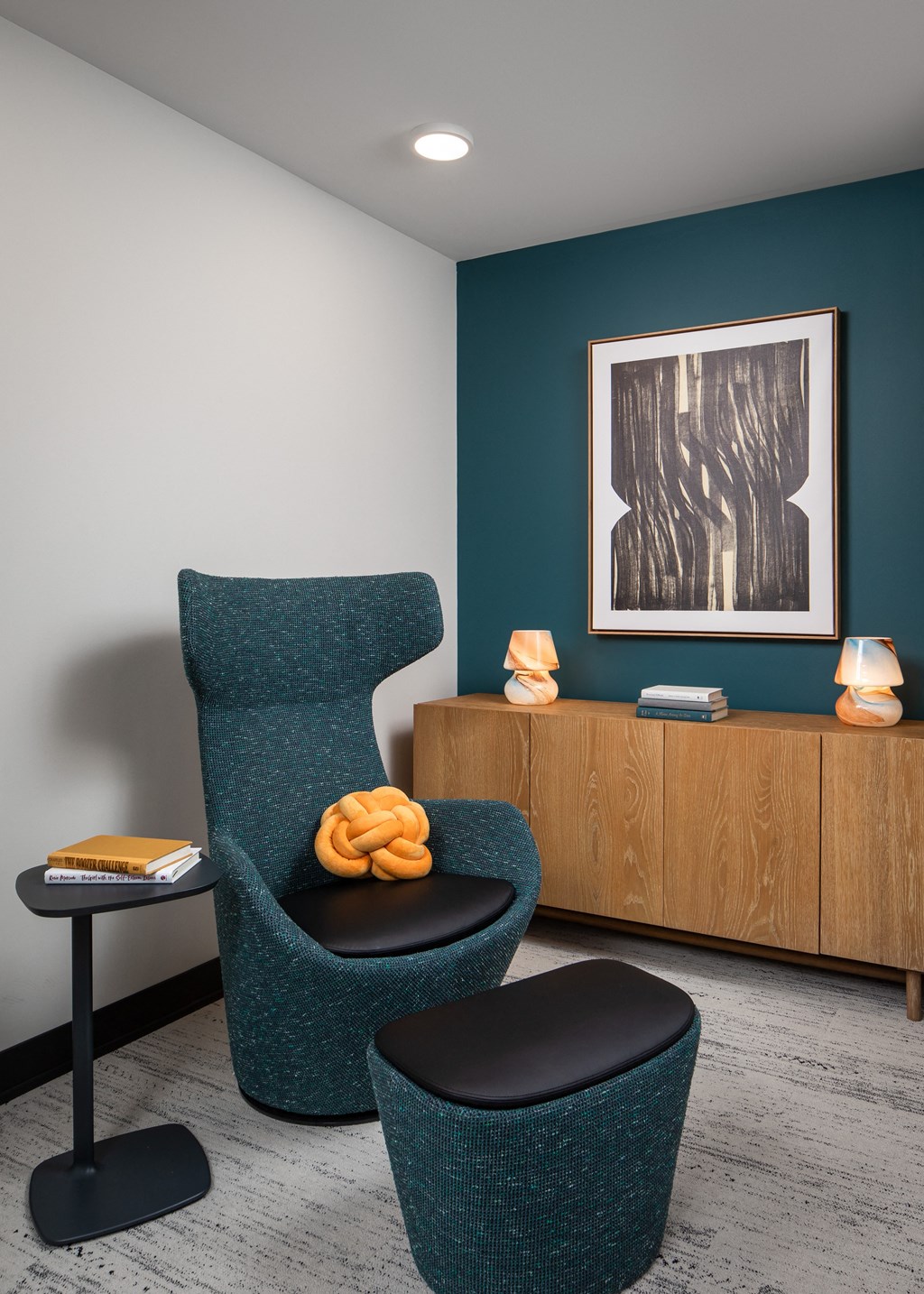 a room with two chairs and a table and a painting on the wall