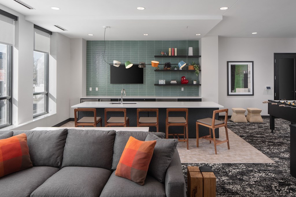 a living room with a couch and a kitchen with a table and chairs