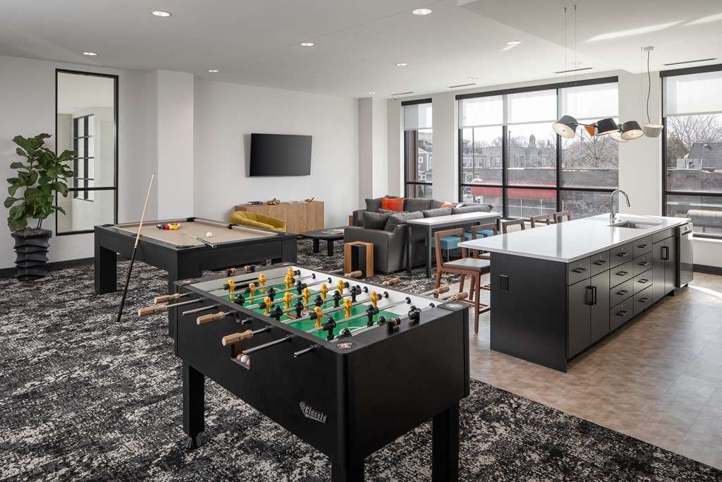an open living room with a foosball table and a games room